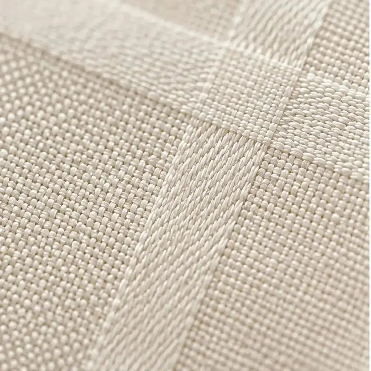 Gros plan sur la texture tissée et le motif à carreaux subtil de la nappe de table beige