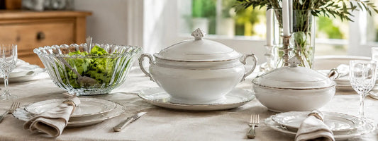 Soupière, légumier et saladier en porcelaine disposés sur une table dressée élégante