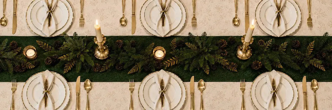 Table de Noël élégante dressée avec porcelaine fine, chandeliers en métal doré et serviettes pliées, tendances 2026