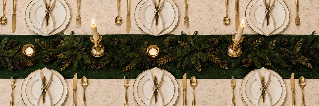 Table de Noël élégante dressée avec porcelaine fine, chandeliers en métal doré et serviettes pliées, tendances 2026