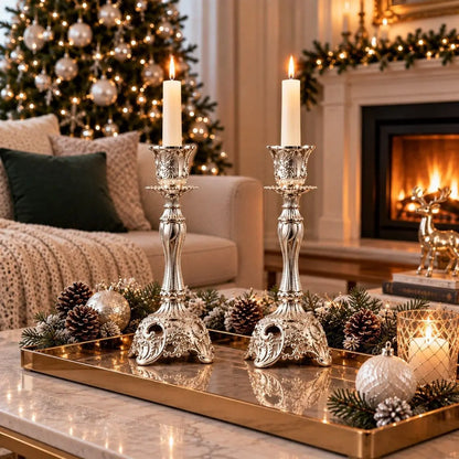 Paire de bougeoirs baroques vintage argentés avec chandelles allumées devant une cheminée et sapin décoré pour Noël