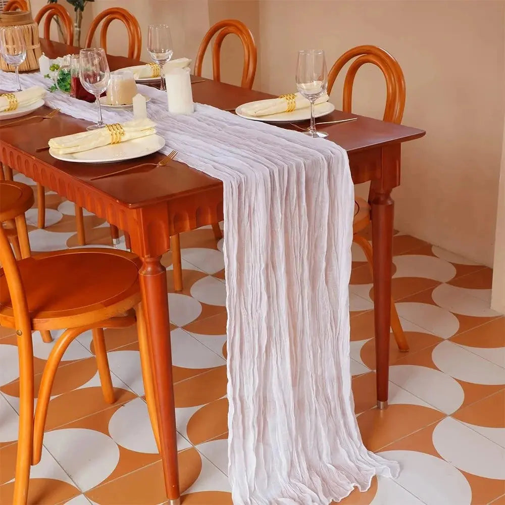 Image d'un chemin de table blanc sur une ravissante table à dîner dans un décor orangé