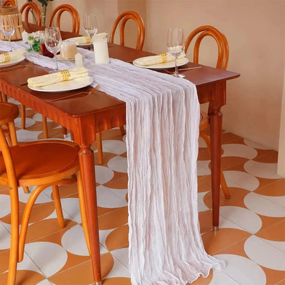 Image d'un chemin de table blanc sur une ravissante table à dîner dans un décor orangé