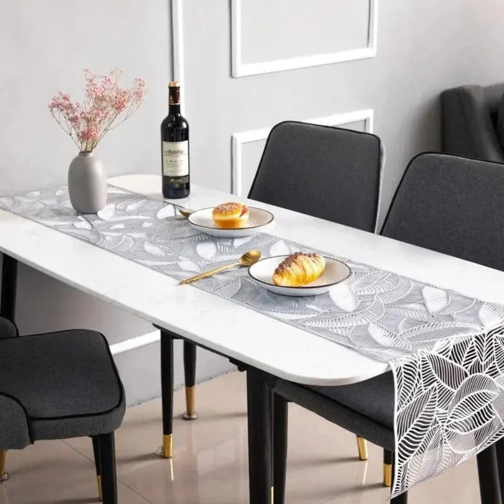 Image d'un magnifique chemin de table argenté au motif de feuille sur une jolie table avec de délicieuses viennoiseries