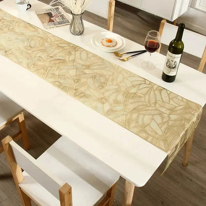 Image d'un magnifique chemin de table doré au motif de feuille sur une jolie table avec un petit verre de vin rouge