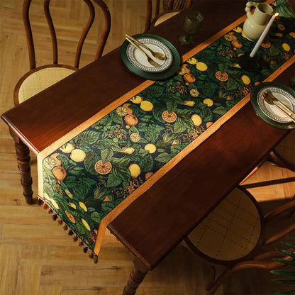 Image d'un élégant chemin de table ayant des agrumes comme motif, déroulé complètement sur une table en bois et avec deux jolis couverts 