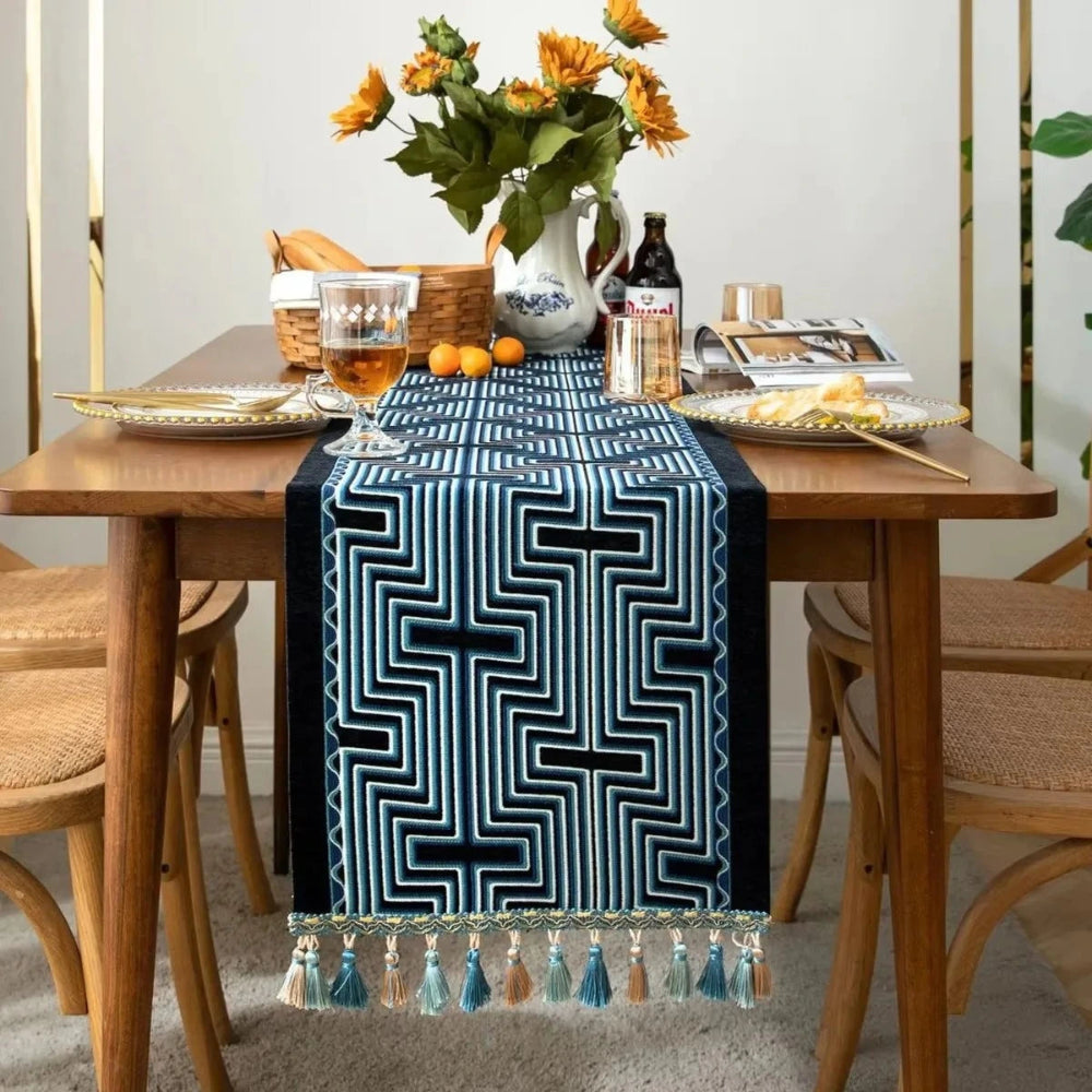 Image d'un chemin de table jacquard aux formes géométriques bleu et noir sur une table en bois avec vue de face
