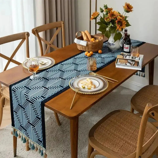 Image d'un chemin de table jacquard aux formes géométriques bleu et noir sur une table en bois