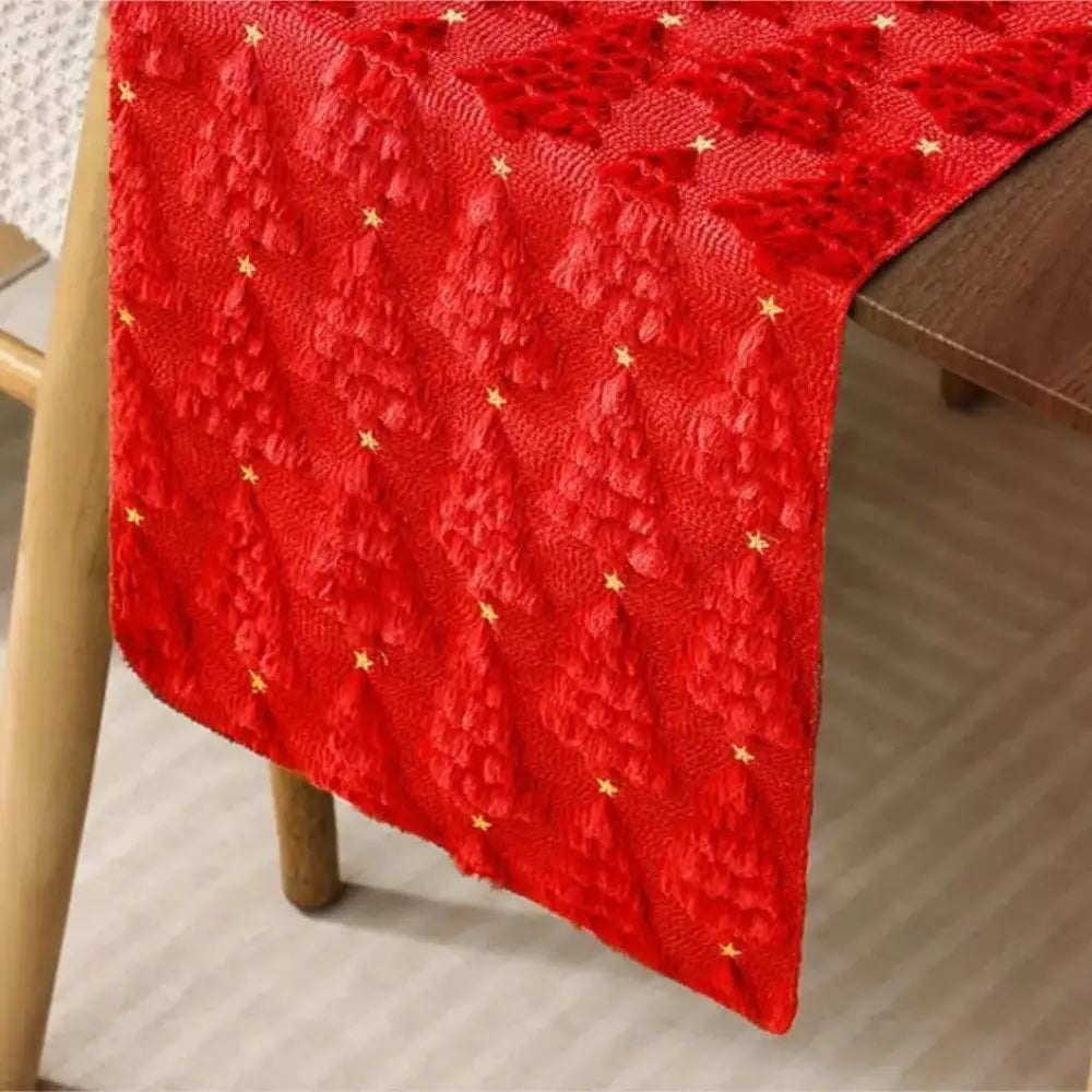 Élégant et doux chemin de table de Noël de couleur rouge avec de petits sapins tissés en relief, vu de très près