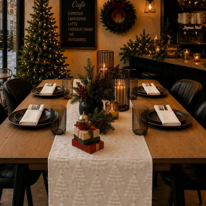 Chemin de table de Noël blanc crème à motifs de sapins texturés, dans un café décoré pour Noël avec cadeaux et bougies