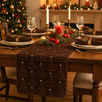 Chemin de table de Noël brun foncé à motifs de sapins texturés, sur table dressée avec bougies et décorations dorées