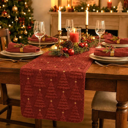 Chemin de table de Noël brun rouge à motifs de sapins texturés, sur table dressée avec bougies et décorations dorées
