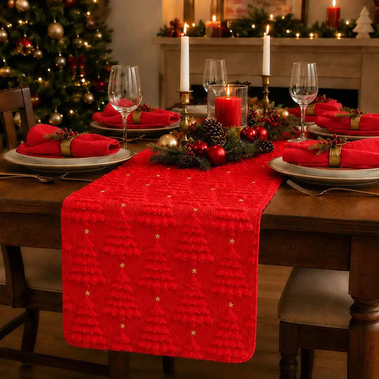 Chemin de table de Noël rouge à motifs de sapins texturés, sur table dressée avec bougies et sapin décoré