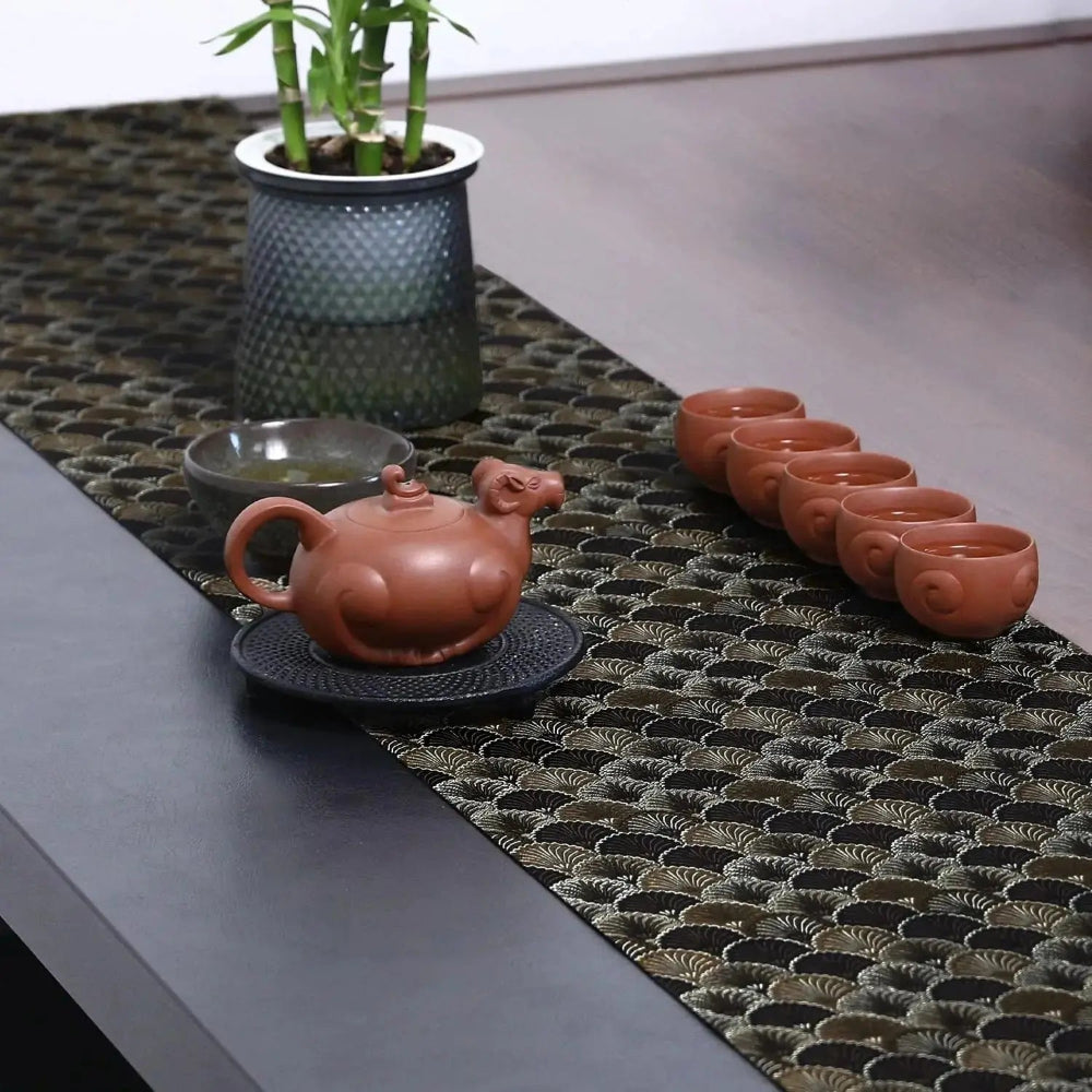 Image d'un élégant chemin de table placé sur une table de style contemporain en bois avec de mignonnes petites tasses à thé 