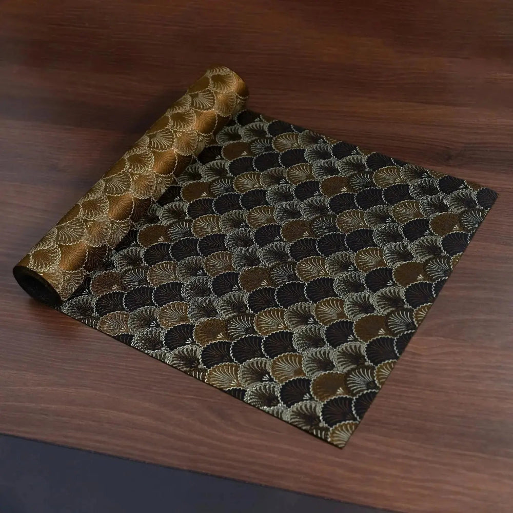 Image d'un élégant chemin de table à motif unique roulé sur une table en bois montrant la réversibilité de celui-ci