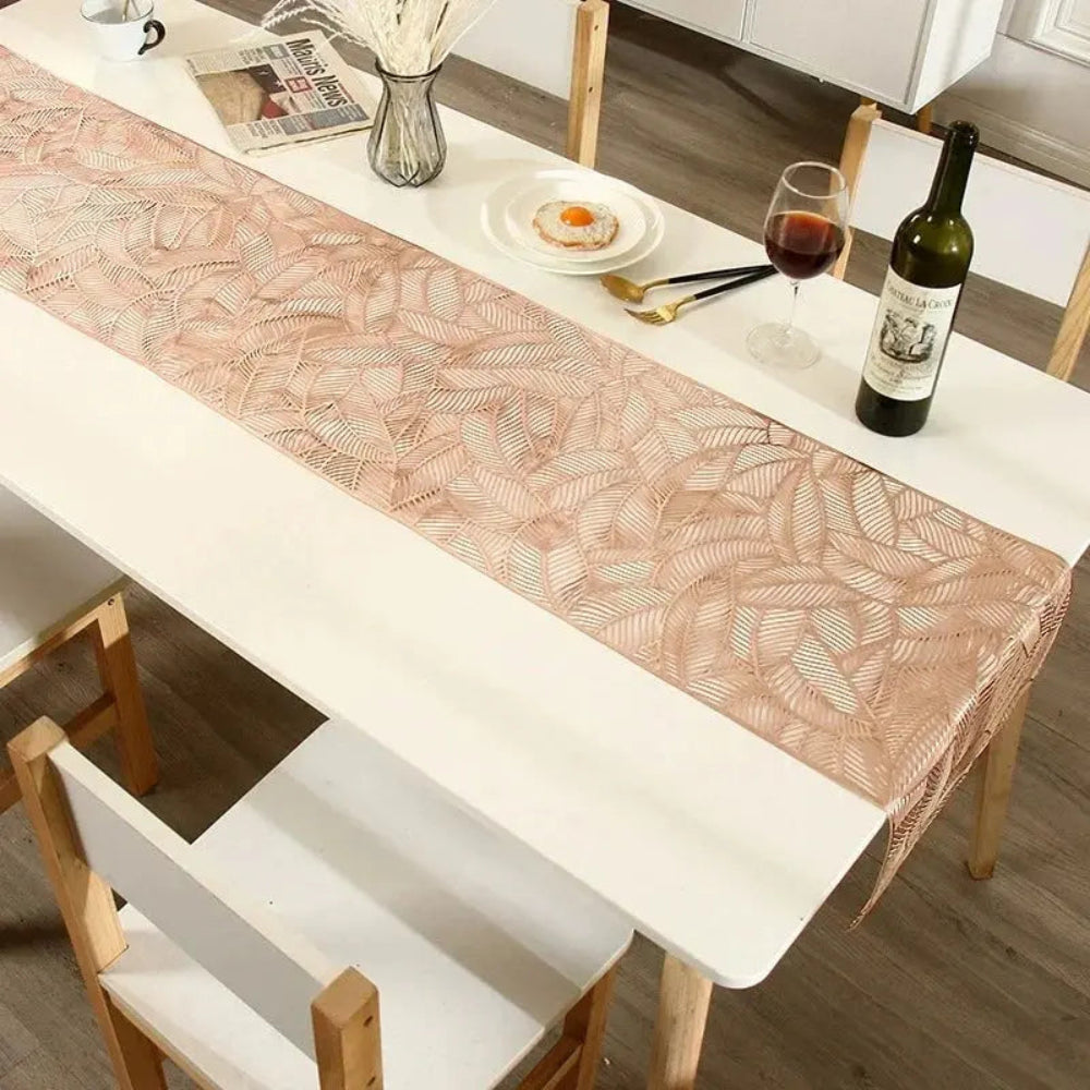 Image d'un magnifique chemin de table rose doré au motif de feuille sur une jolie table à l'apéro