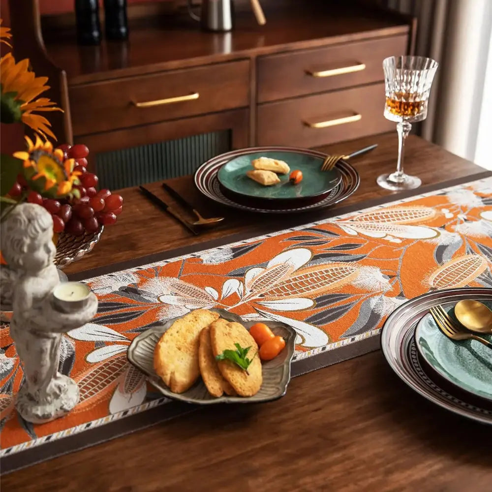 Image d'un magnifique et coloré chemin de table de style vintage avec un motif épi placé sur une belle table en bois accompagné de deux  couverts et un bougeoir
