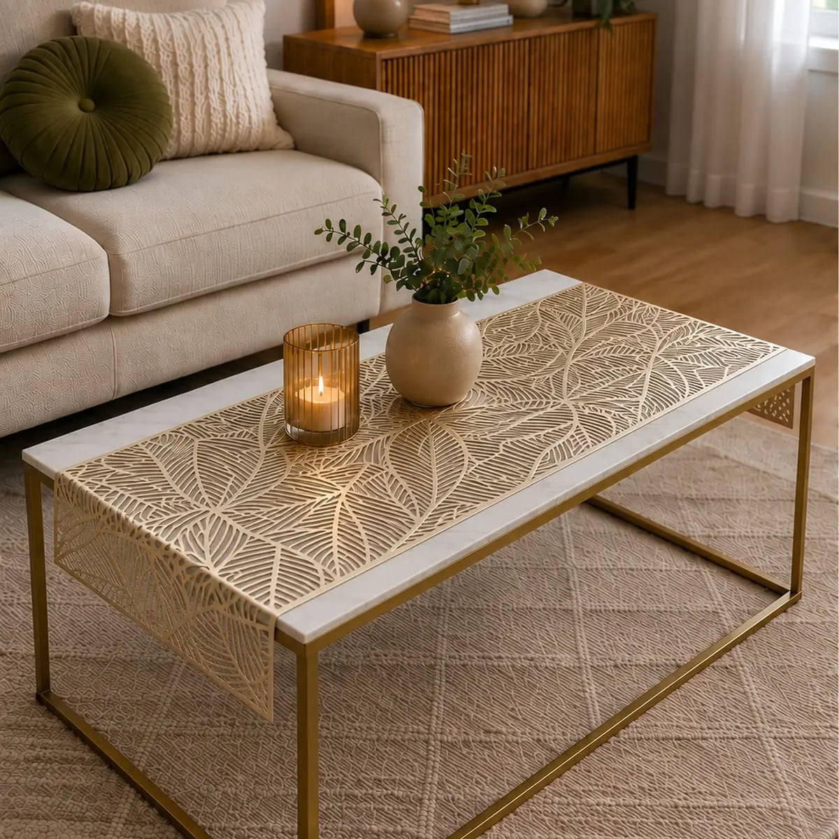 Chemin de table vinyle doré au motif de feuille utilisé sur table à café, dans un salon avec bougie et vase