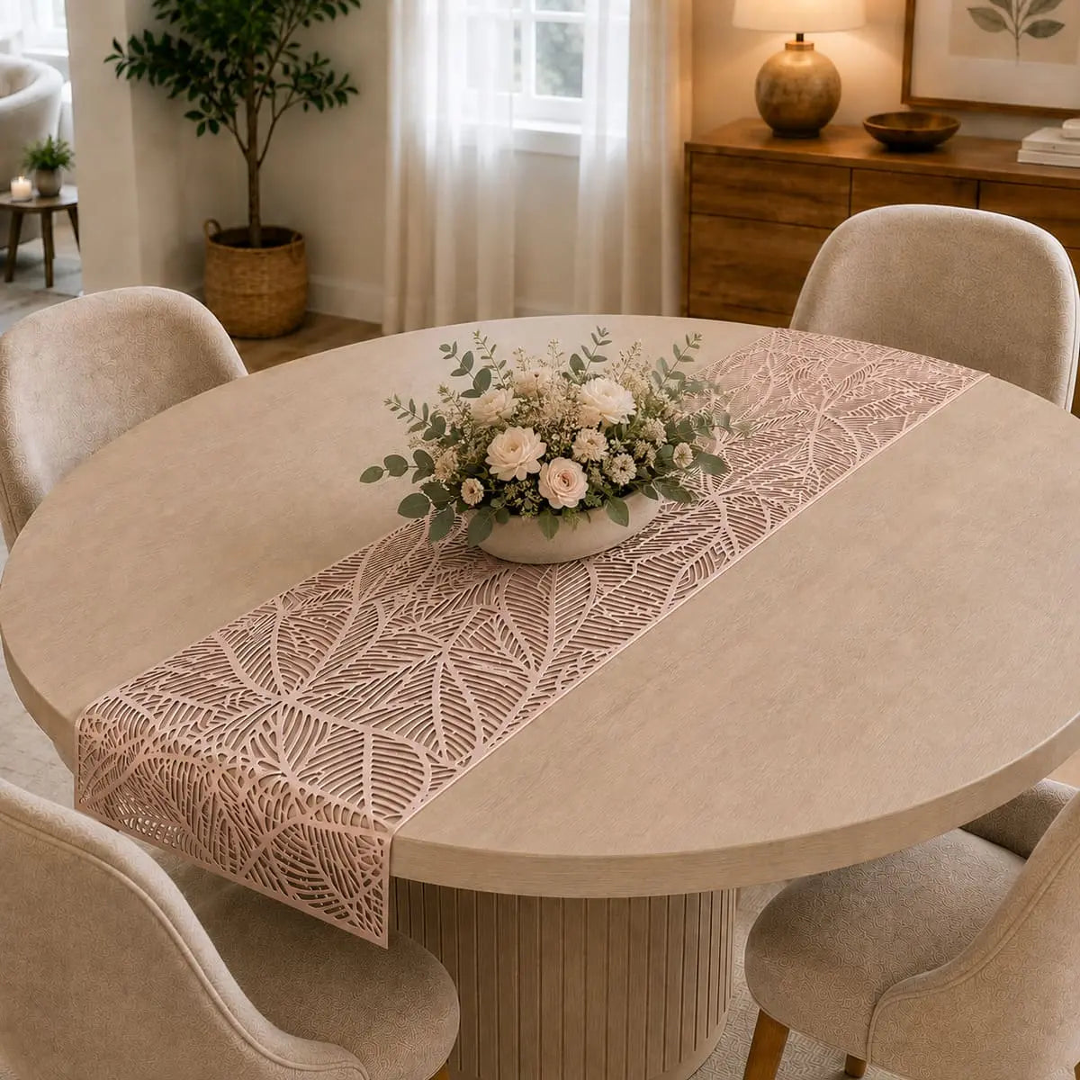 Chemin de table vinyle rose doré au motif de feuille sur table ronde, avec bouquet de roses blanches et eucalyptus