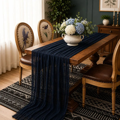 Chemin de table voilage plissé bleu marine sur table en bois avec bouquet d'hortensias bleus et blancs