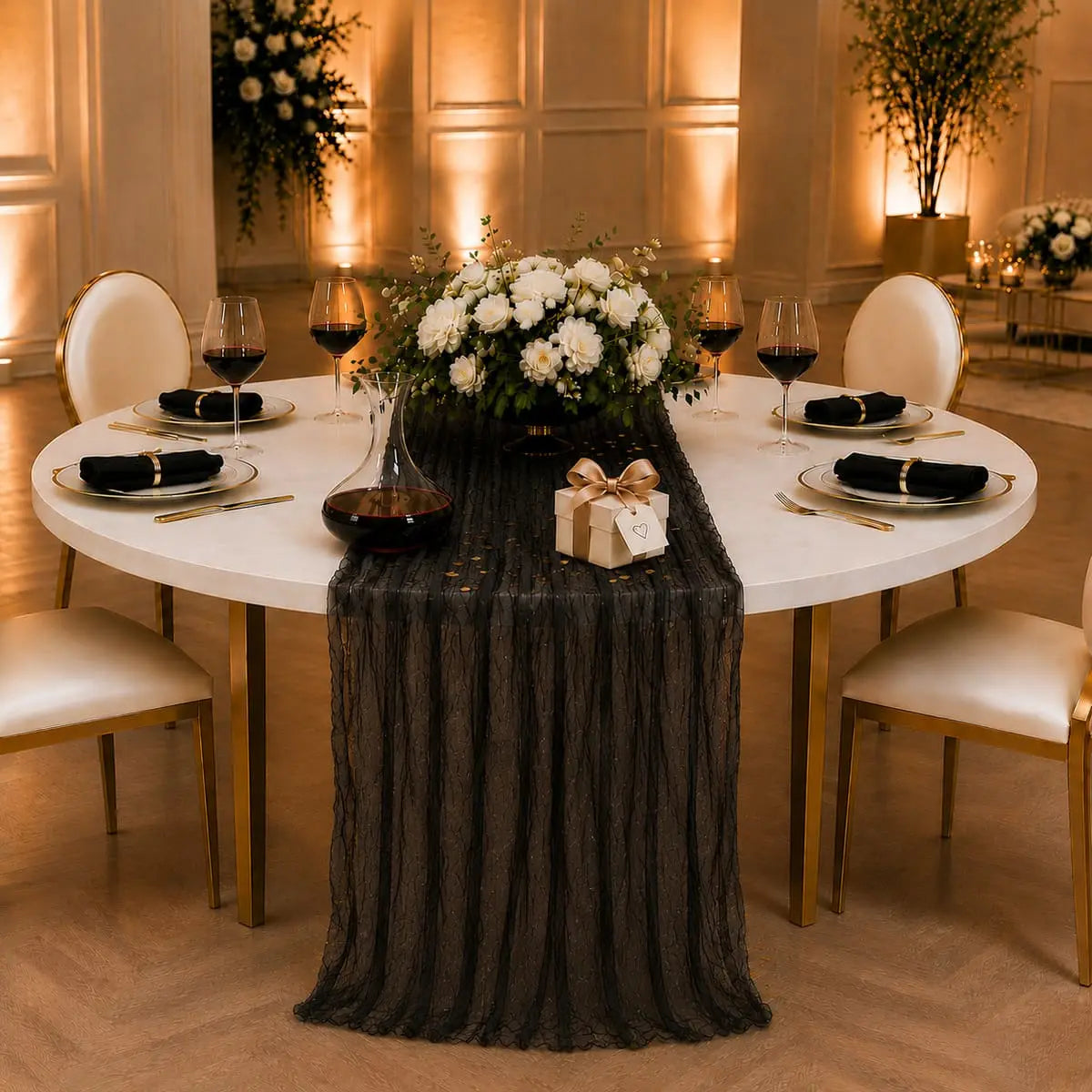 Chemin de table voilage plissé noir sur table ronde, ambiance romantique avec roses blanches, bougies et cadeau