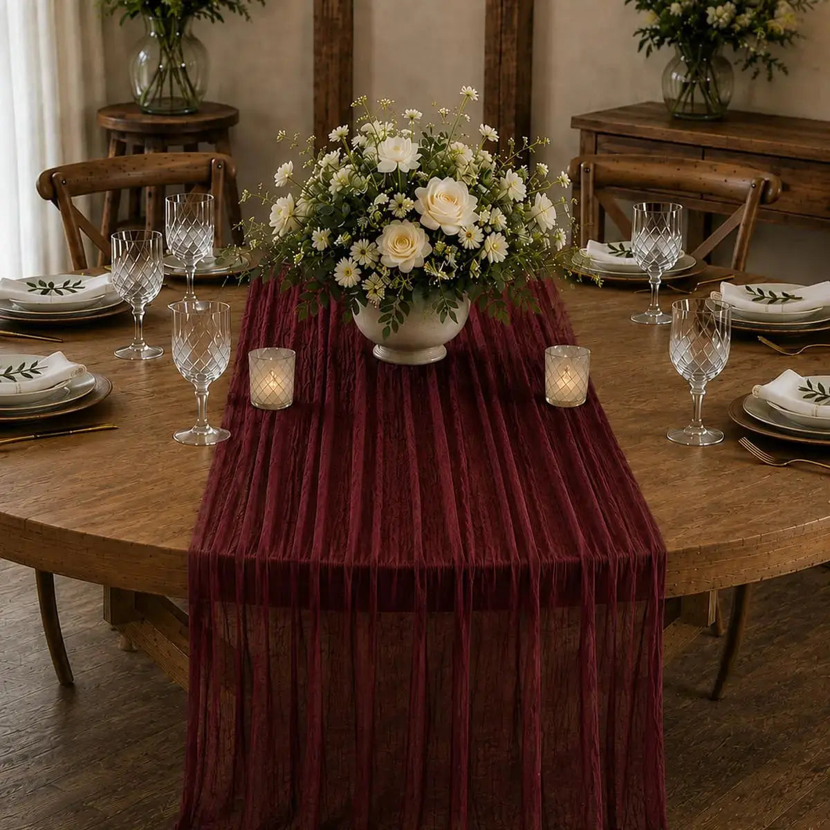 Chemin de table voilage plissé rouge vin sur table élégante avec centre de table floral
