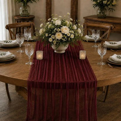 Chemin de table voilage plissé rouge vin sur table élégante avec centre de table floral