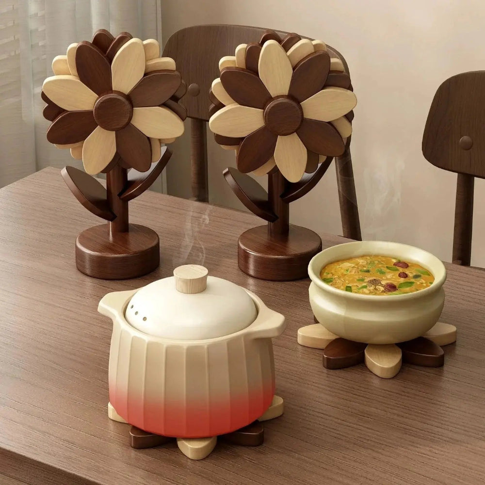 Image de dessous de plat en bois de couleur brun et beige en forme de tournesol sur une table rectangulaire en bois avec des plats chauds sur le dessus