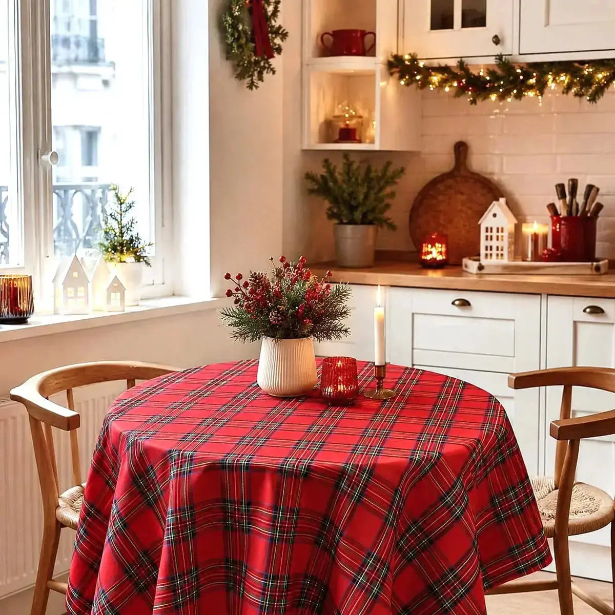 Nappe de Noël à carreaux rouge foncé en format rond, sur une petite table de cuisine près d'une fenêtre