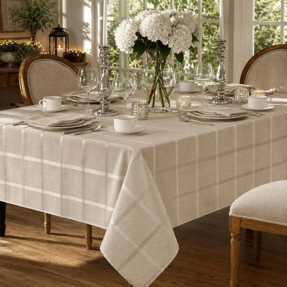 Nappe de table beige à carreaux habillant une table à manger dressée près d'une grande fenêtre