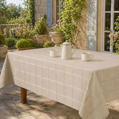 Nappe de table beige à carreaux sur une terrasse en pierre, ambiance campagne française avec service à café