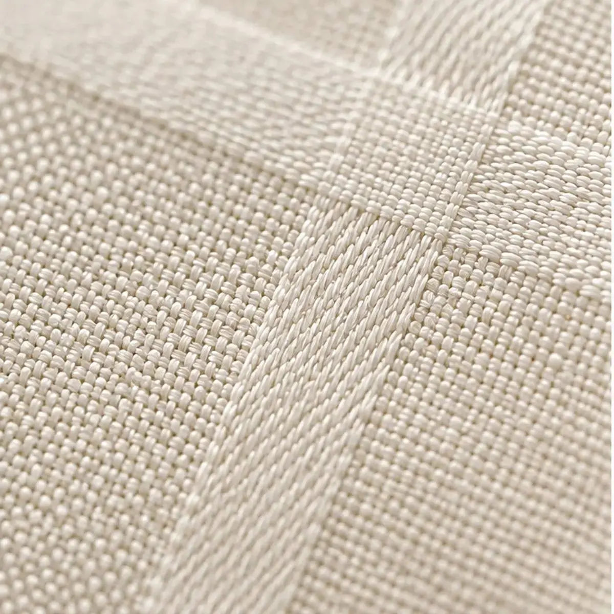 Gros plan sur la texture tissée et le motif à carreaux subtil de la nappe de table beige