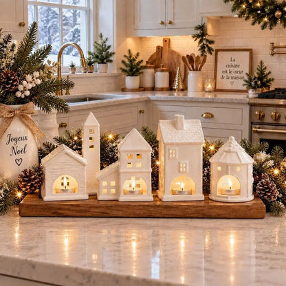 Village de photophores en céramique sur un comptoir de cuisine décoré pour Noël